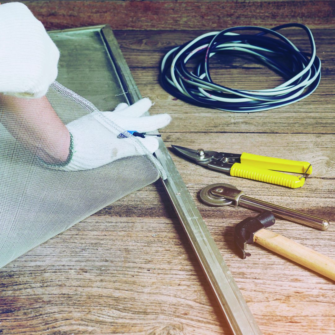 Man is working with mosquito wire screen installation